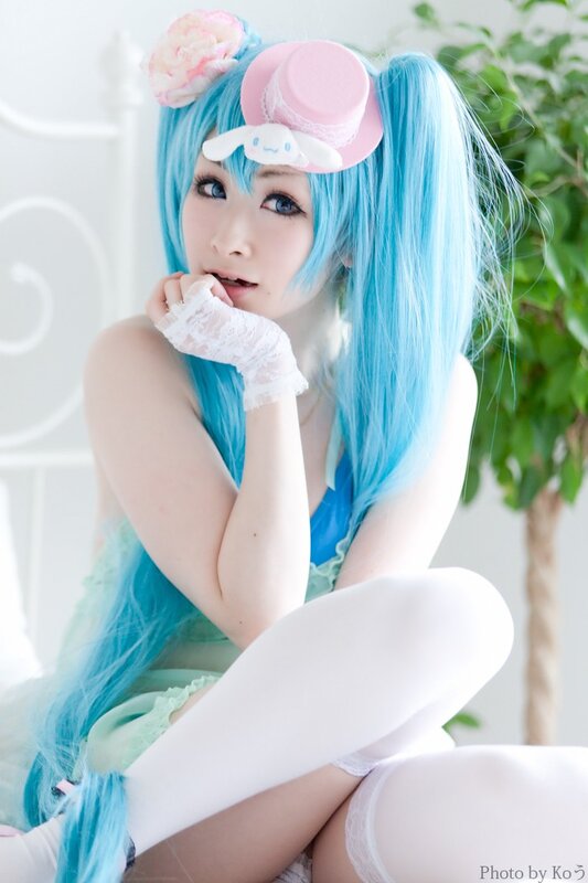 cosplayer in blue wig and pink hat