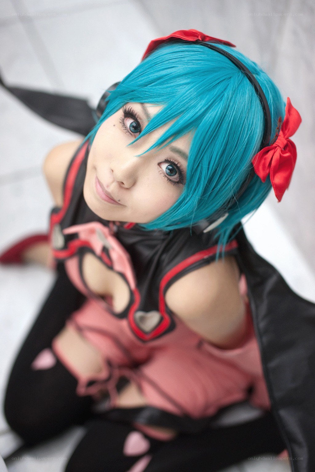 cosplayer in blue wig and red bow