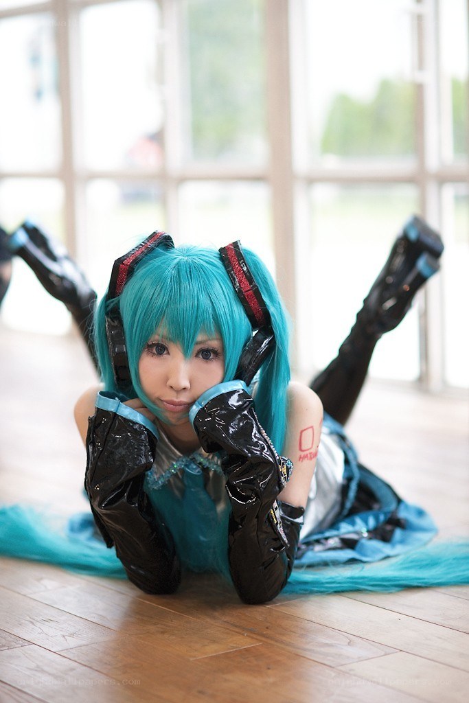 cosplayer in blue wig lying on floor