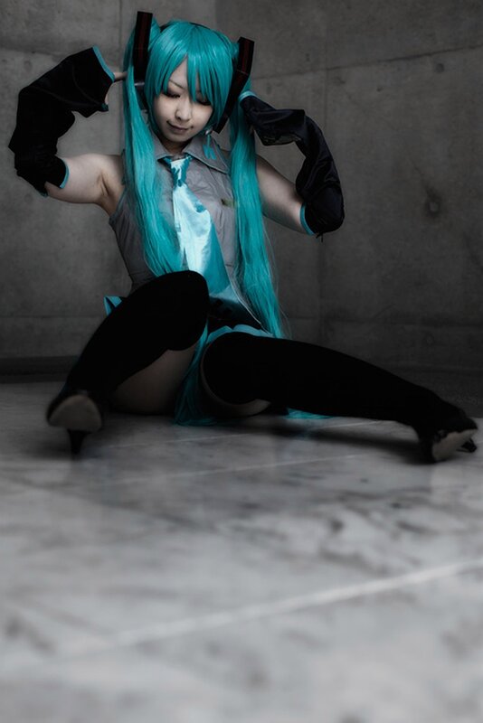cosplayer in blue wig sitting