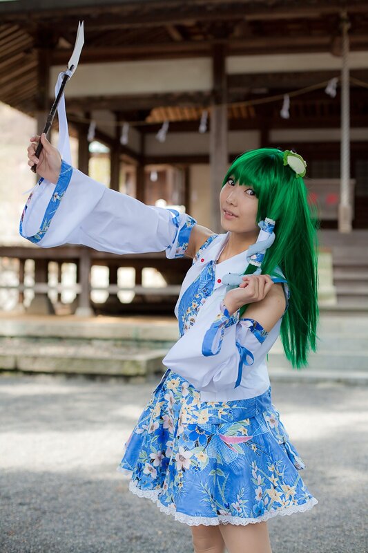 cosplayer in green wig and blue dress