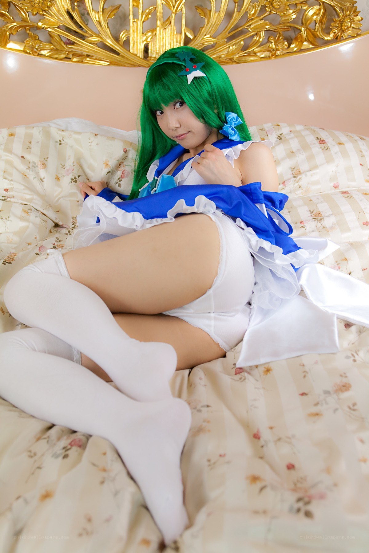 cosplayer in green wig on bed