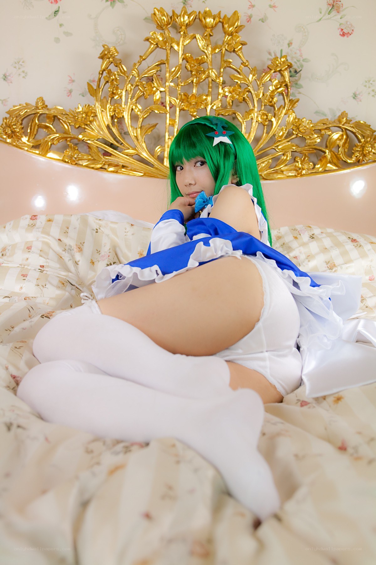 cosplayer in green wig on bed