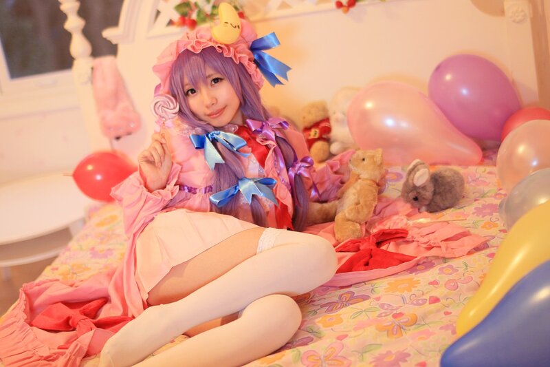 cosplayer in pink dress on bed