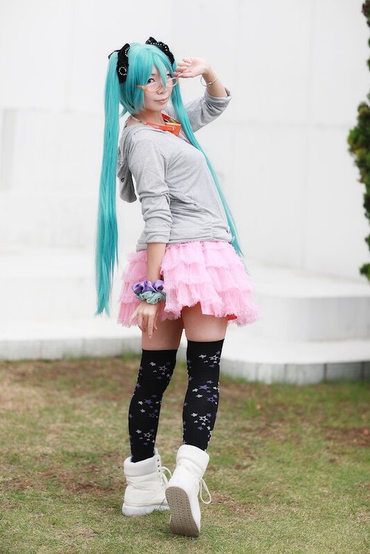 cosplayer in pink skirt and blue wig
