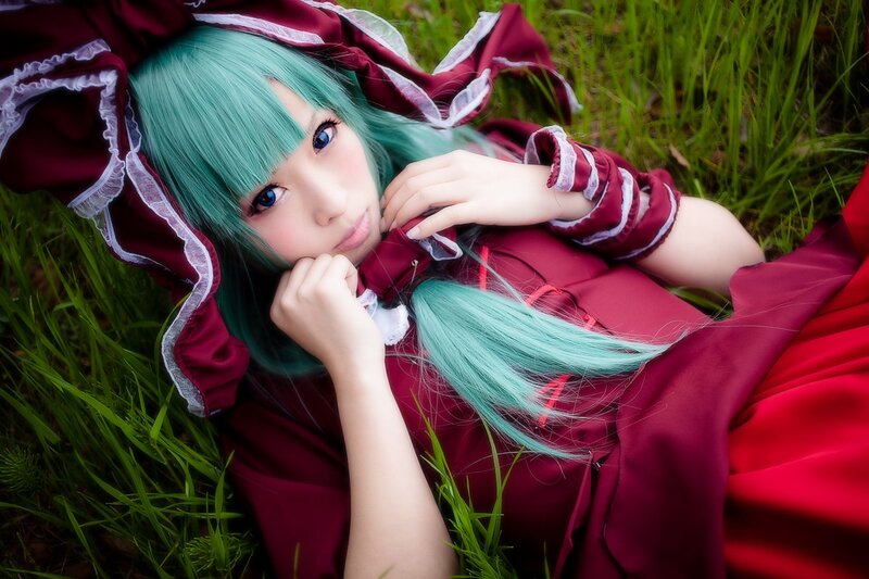 cosplayer in red dress lying on grass
