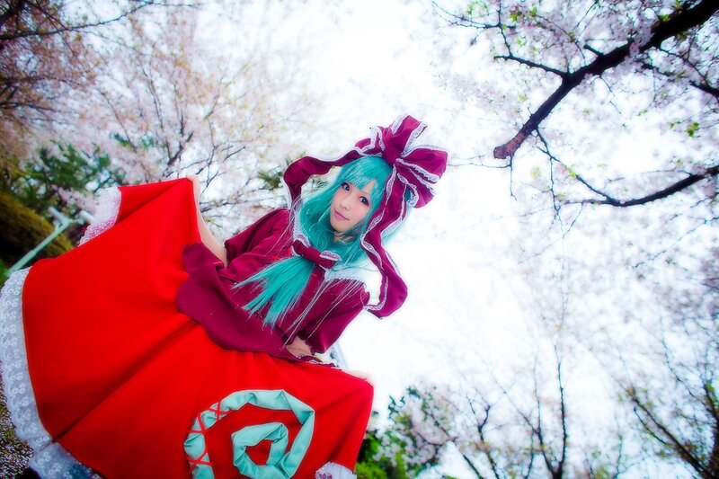 cosplayer in red dress under cherry blossoms