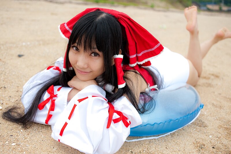 cosplayer on beach in red and white outfit
