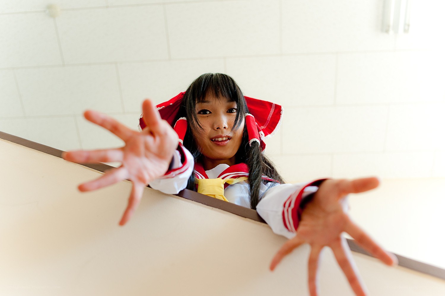 cosplayer reaching out from behind barrier