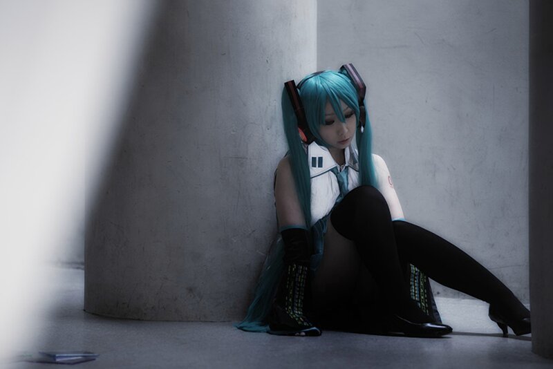 cosplayer sitting against a wall