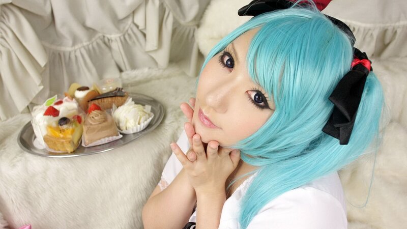 cosplayer with blue hair and desserts