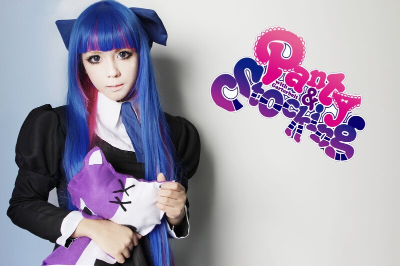 cosplayer with blue hair and plush toy