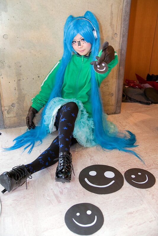 cosplayer with blue hair and smiley faces