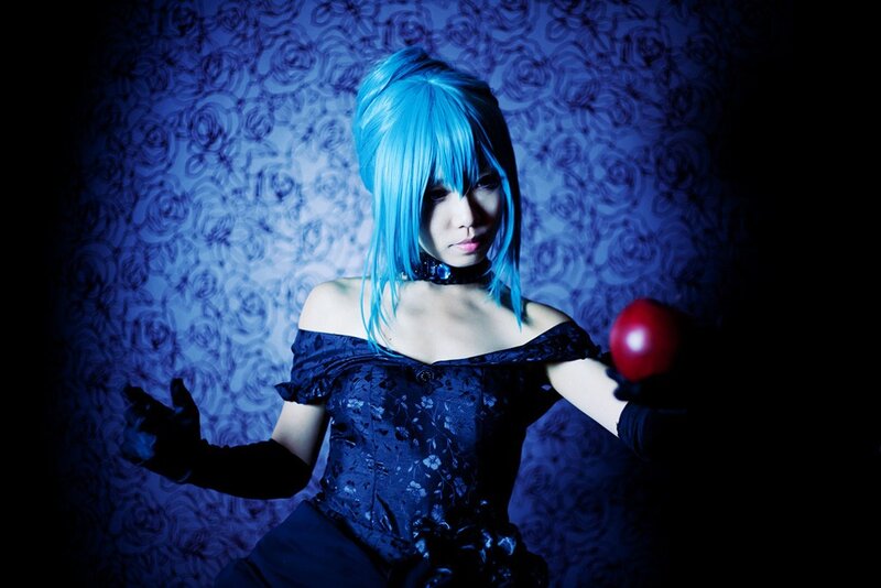 cosplayer with blue hair holding apple