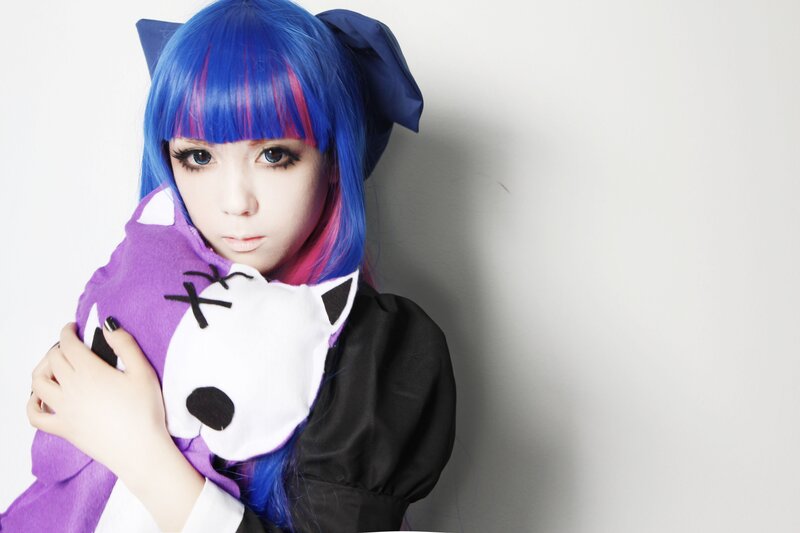 cosplayer with blue hair holding plush