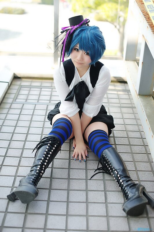 cosplayer with blue hair sitting