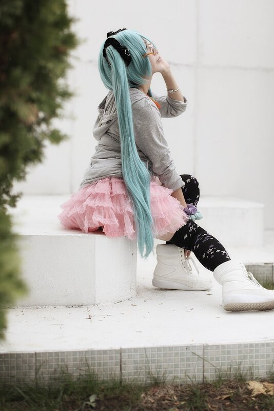 cosplayer with blue hair sitting