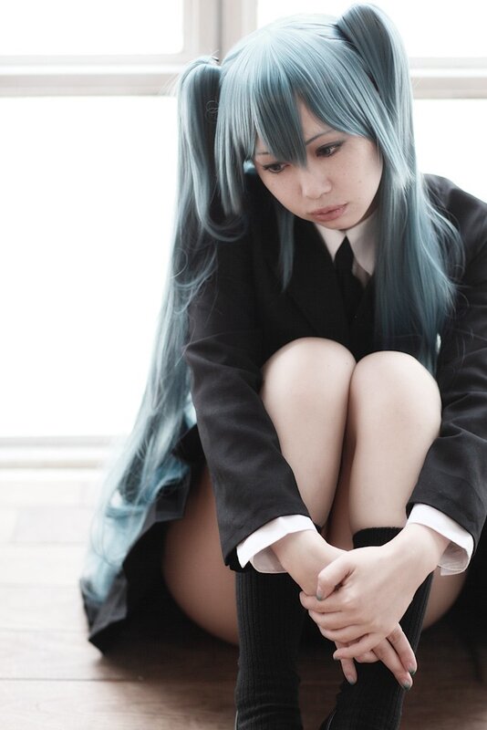 cosplayer with blue hair sitting