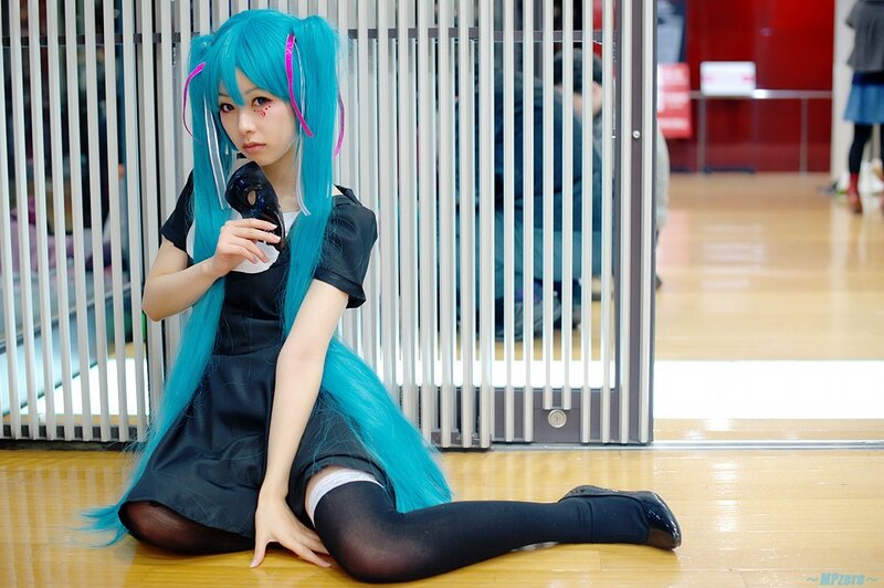 cosplayer with blue hair sitting on floor