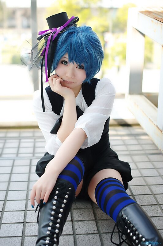 cosplayer with blue hair sitting