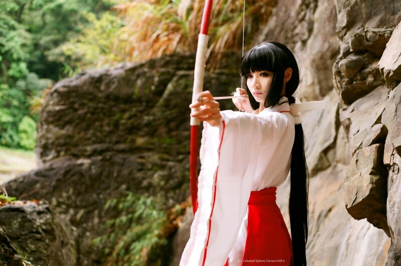 cosplayer with bow in forest
