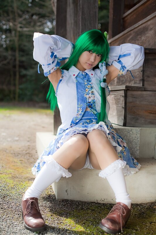 cosplayer with green hair sitting