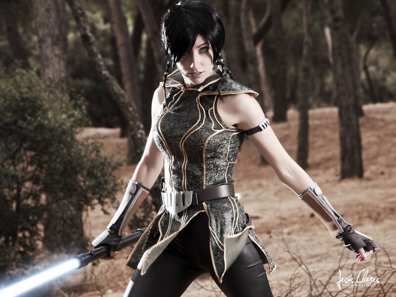 cosplayer with lightsaber in forest