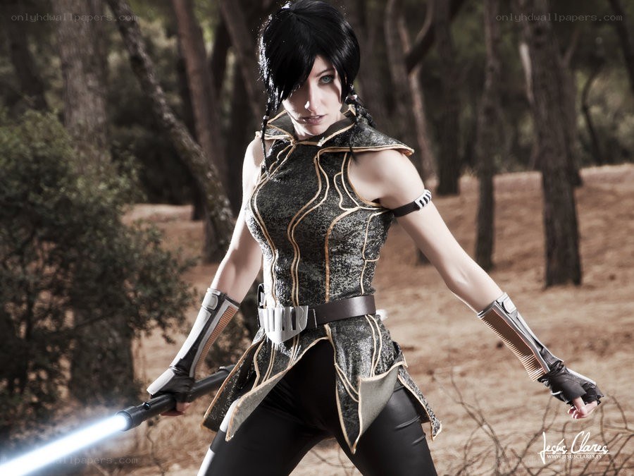 cosplayer with lightsaber in forest