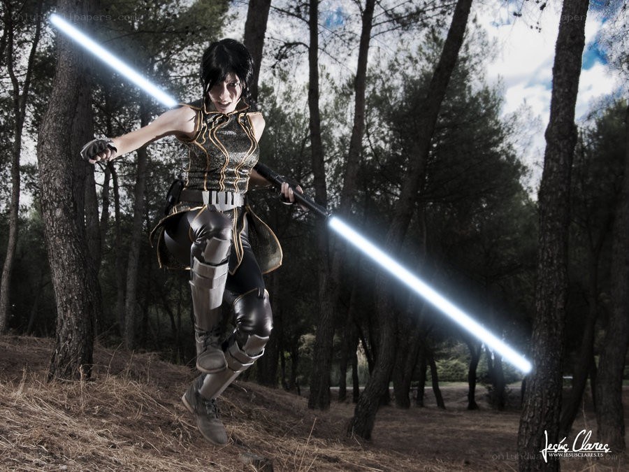 cosplayer with lightsabers in forest