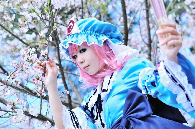 cosplayer with pink hair in cherry blossoms