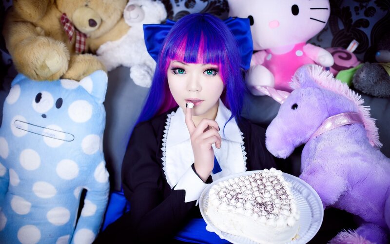 cosplayer with purple hair and cake