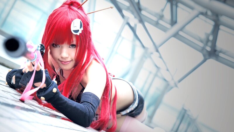 cosplayer with red hair and gun