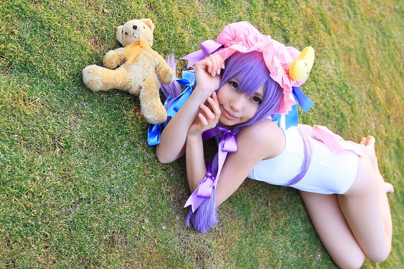 cosplayer with teddy bear on grass