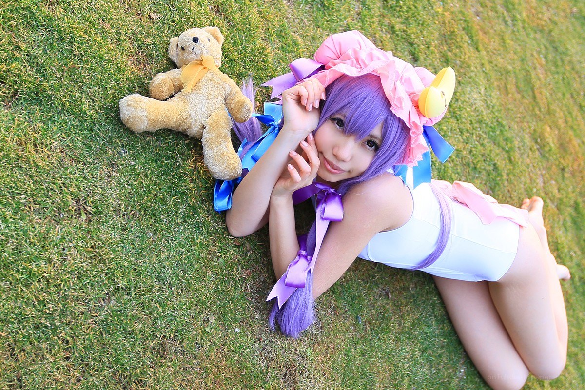 cosplayer with teddy bear on grass