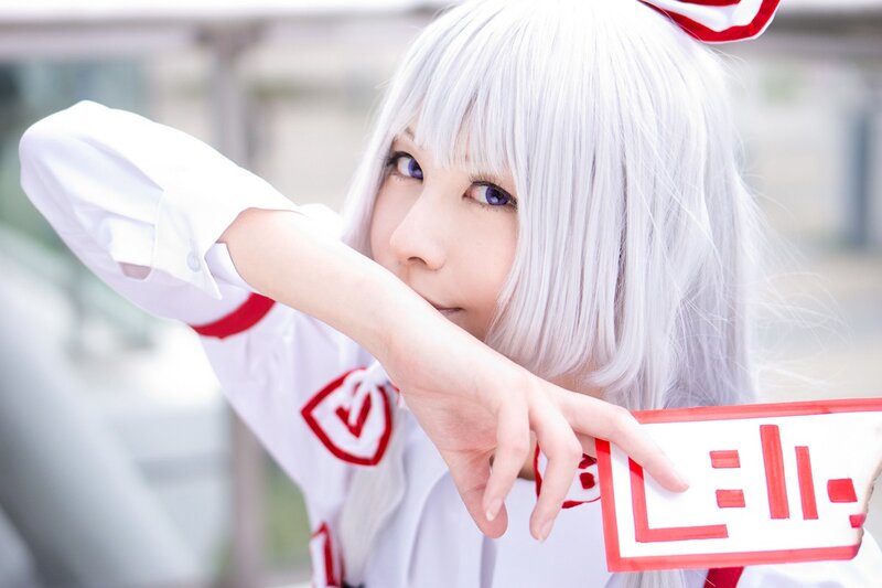 cosplayer with white hair and red bow