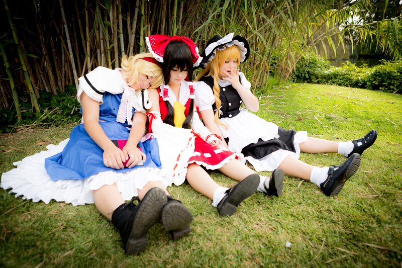 Cosplayers resting on grass