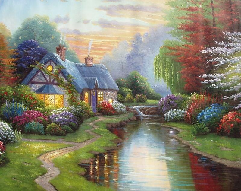 Cottage by a stream at sunset