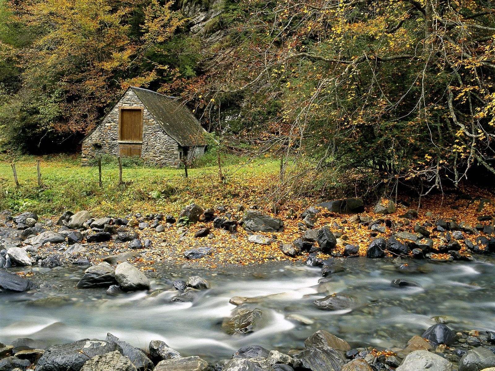 Cottage by a stream in autumn