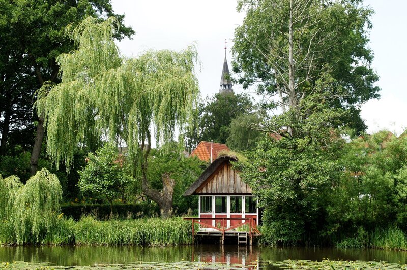 Cottage by the water with church steeple