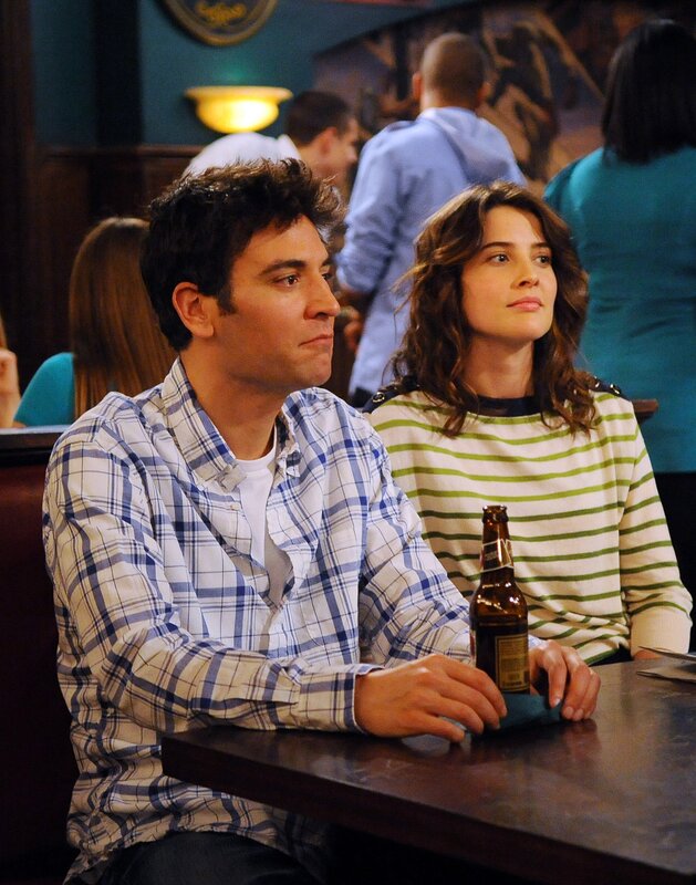 Couple at a bar watching something
