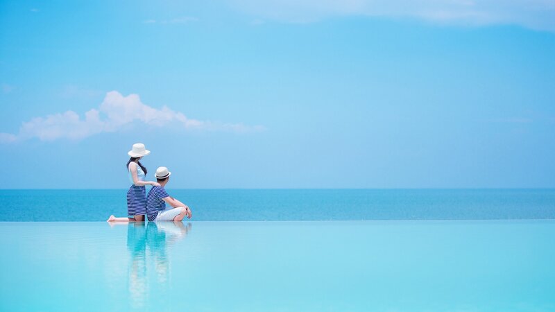 Couple at Infinity Pool — Blue, Serene, Afternoon