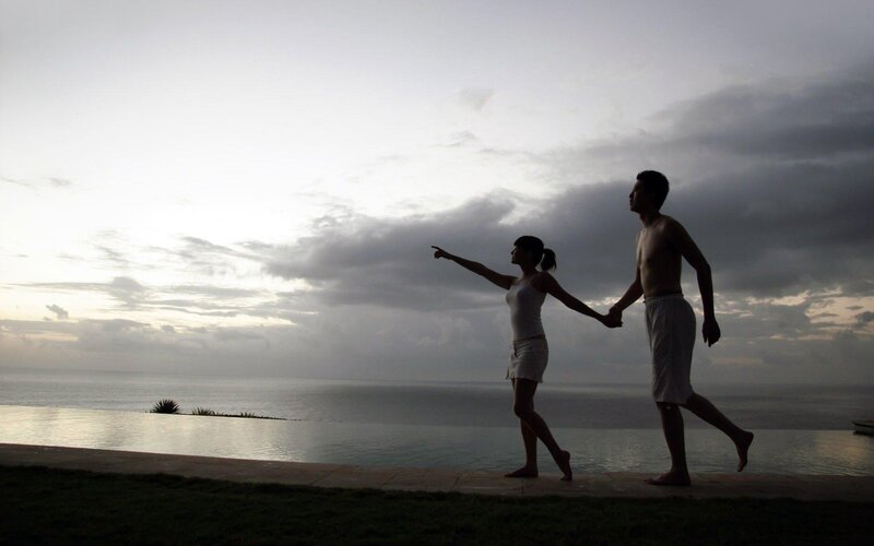 Couple at infinity pool overlooking ocean