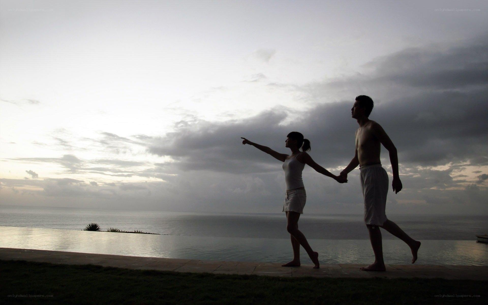 Couple at infinity pool overlooking ocean