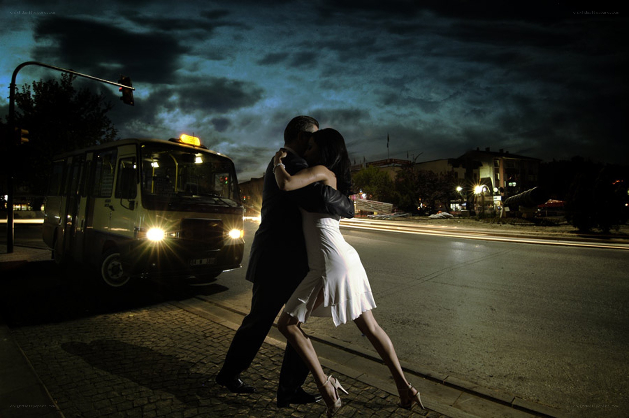 Couple dancing on street at night