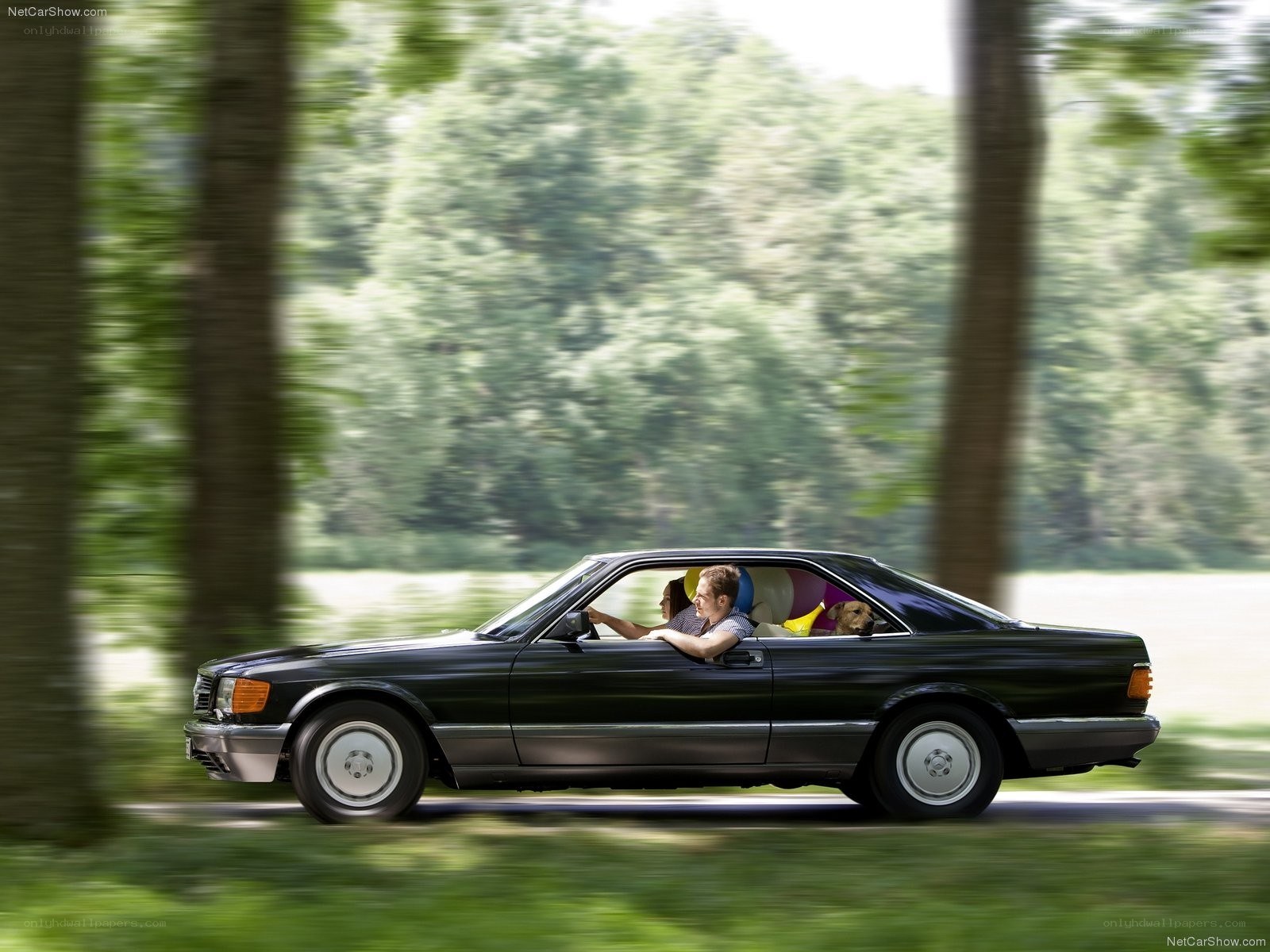 Couple driving black coupe