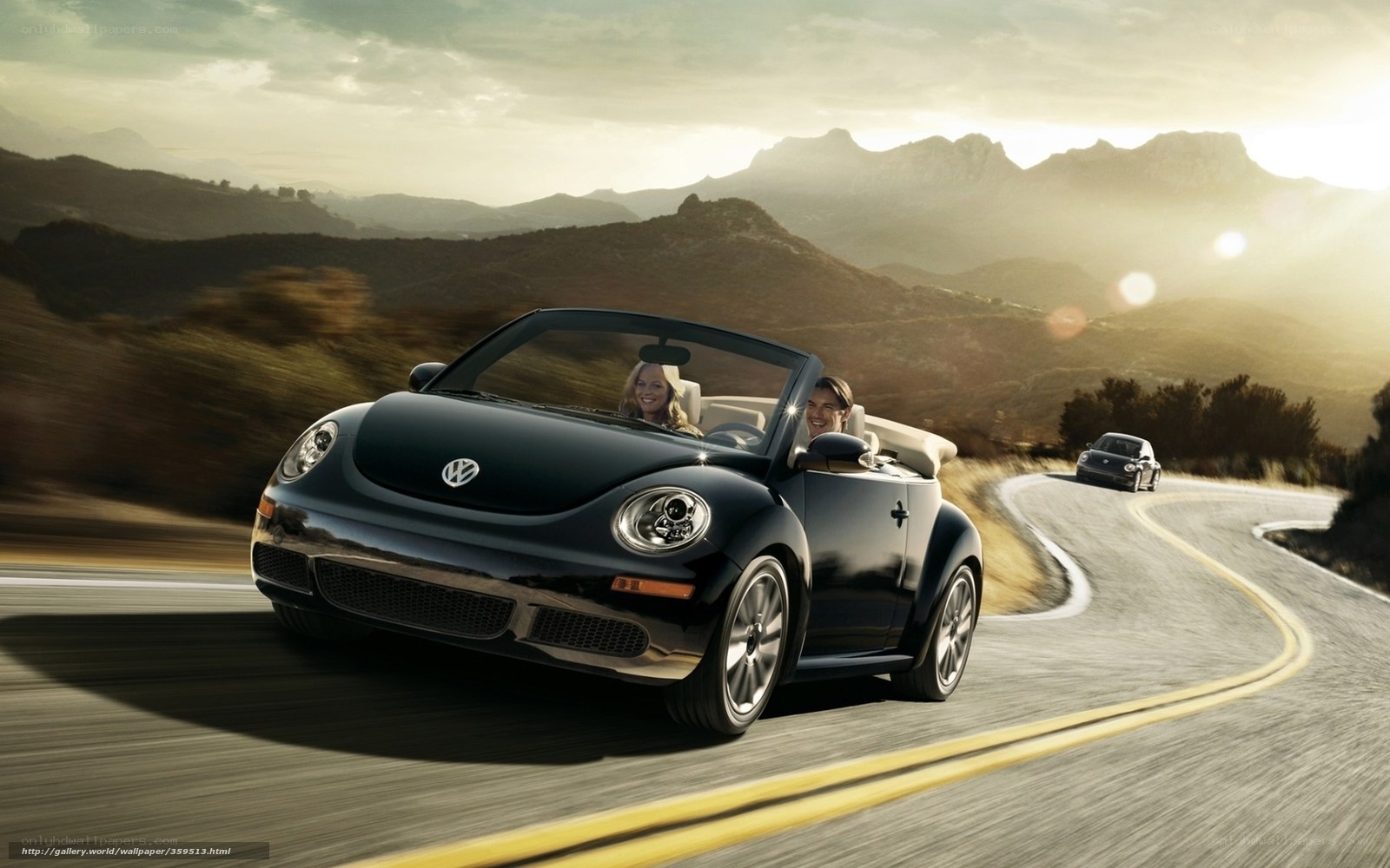 Couple driving convertible on mountain road
