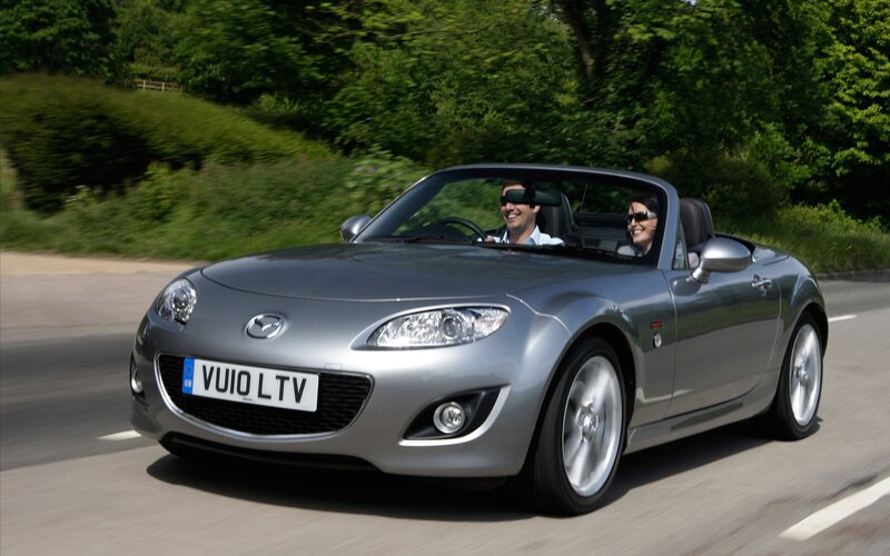 Couple driving silver convertible