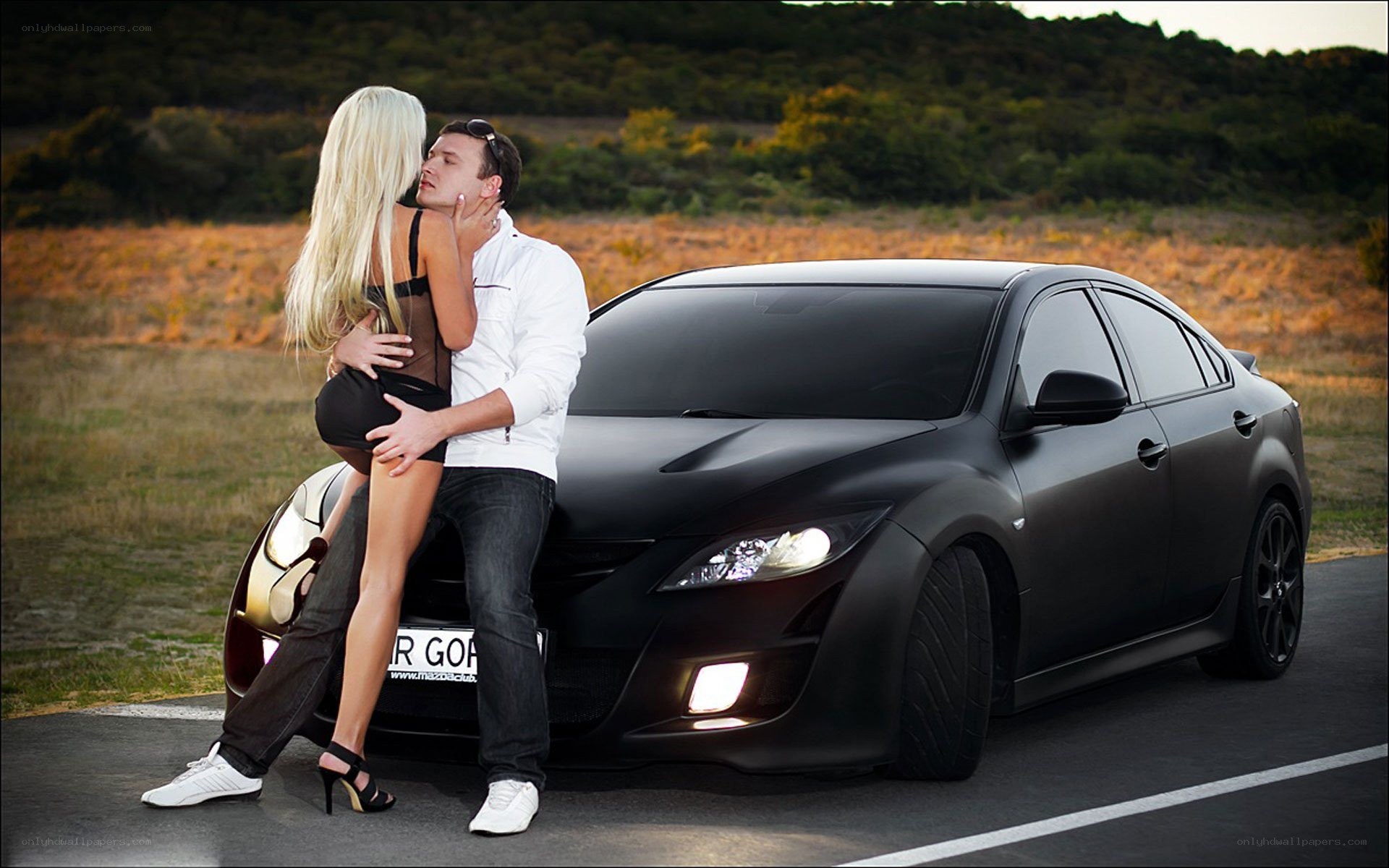 Couple embracing by black car