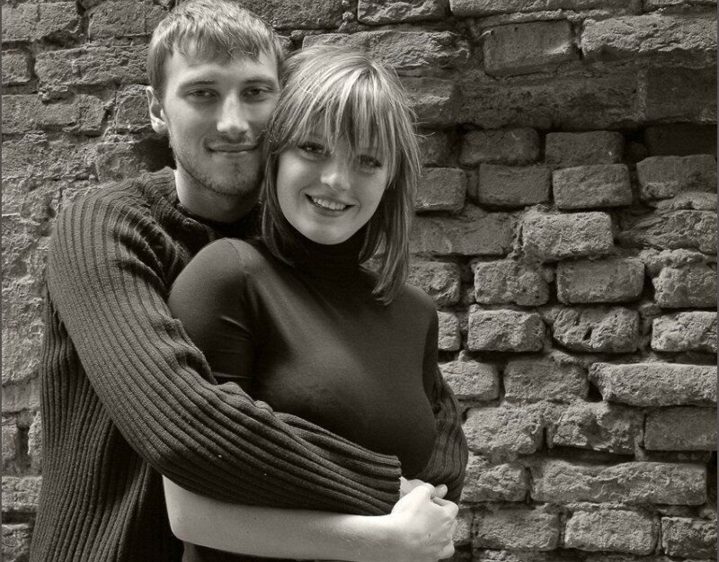couple embracing by brick wall