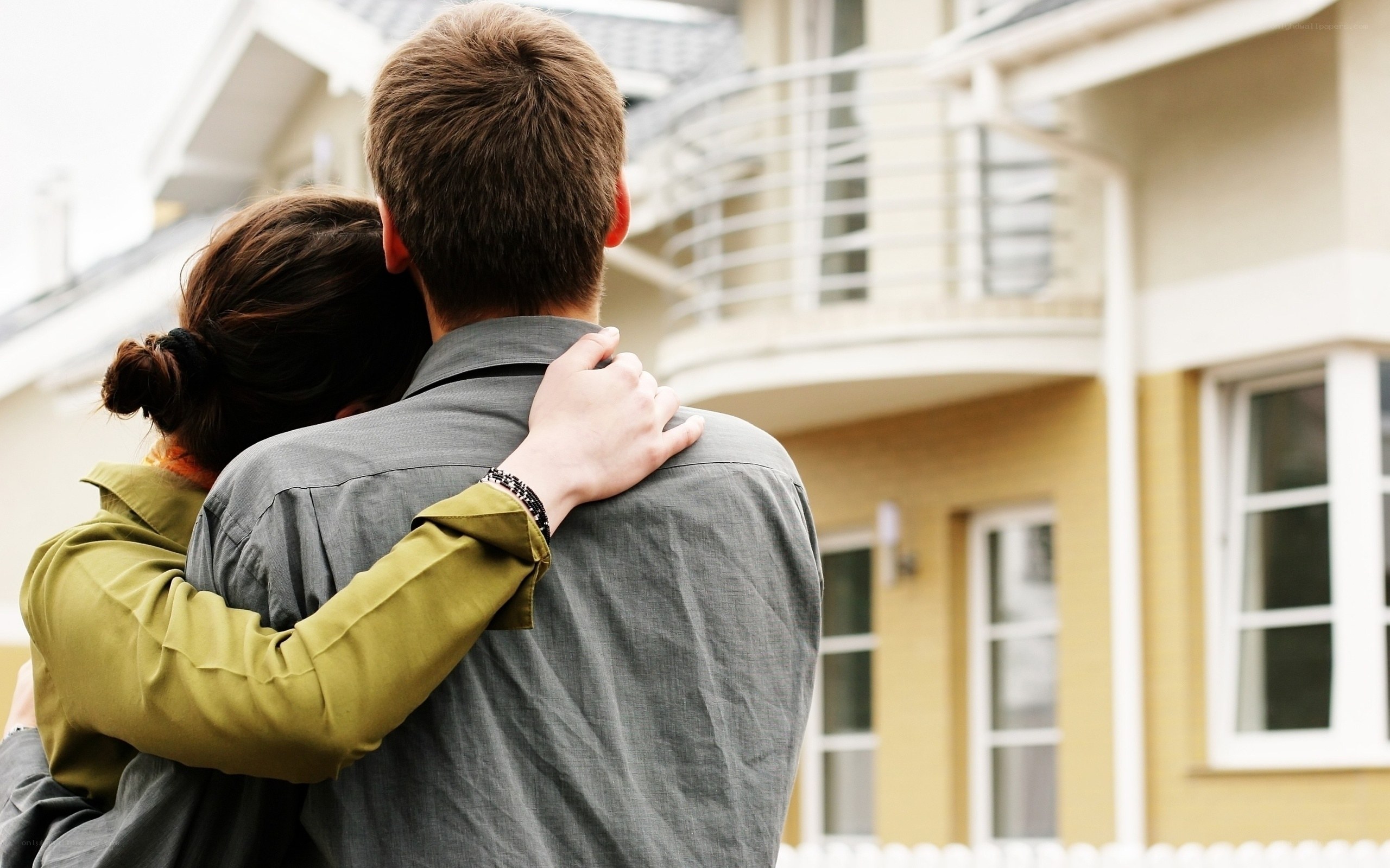 couple embracing by new home